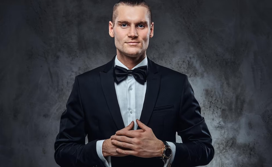 A man wearing a formal suit with a bow tie.