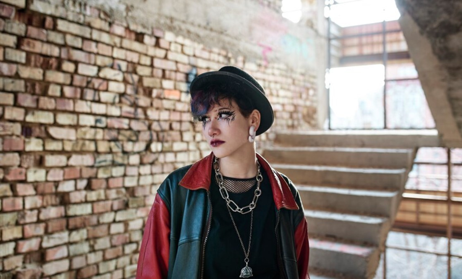 A woman wearing punk outfit with metal accessories.